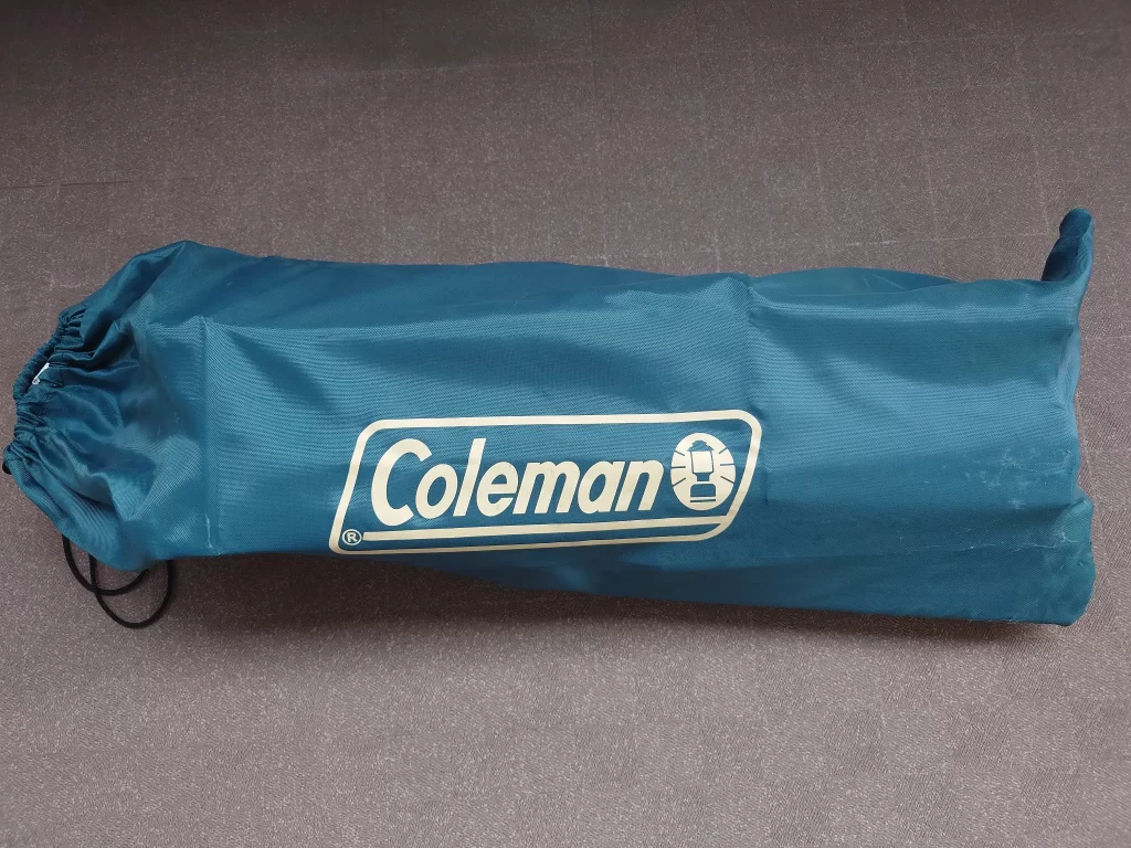 収納袋に入った状態のコールマン ナチュラルウッドロールテーブル90。パーツがコンパクトに収められている様子