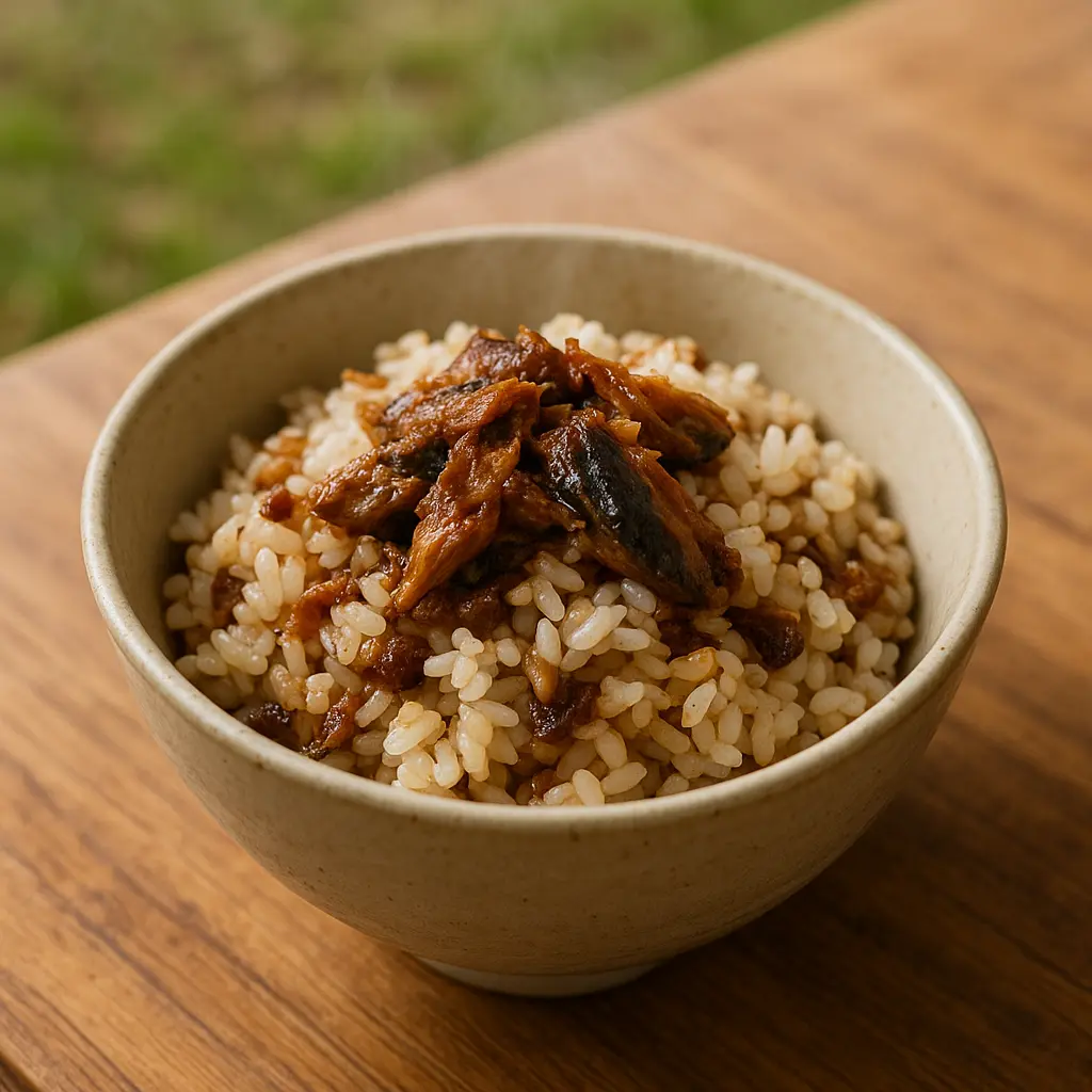 器に盛られたご飯の上にサバ味噌がのり、軽く混ぜてある。背景はキャンプテーブル。