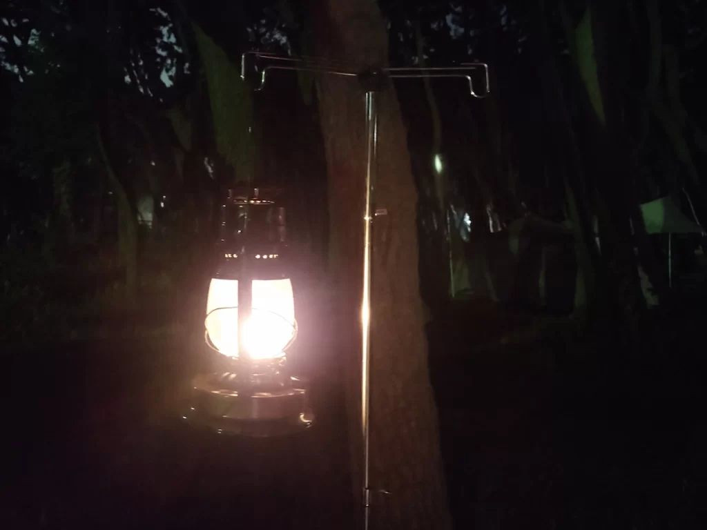 ランタンスタンドに吊るしたDIETZ 90を夜間の林間サイトで点灯